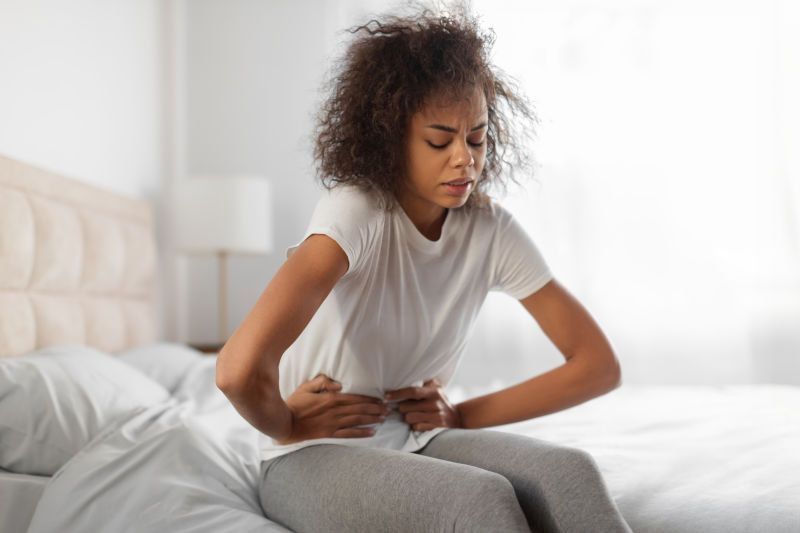 Woman holding her stomach, experiencing discomfort