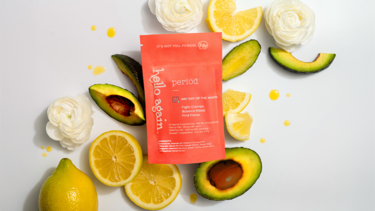 Hello Again Period CBD suppositories displayed with lemons, avocado, and white flowers, highlighting plant-powered ingredients used in CBD suppositories for menstrual pain.