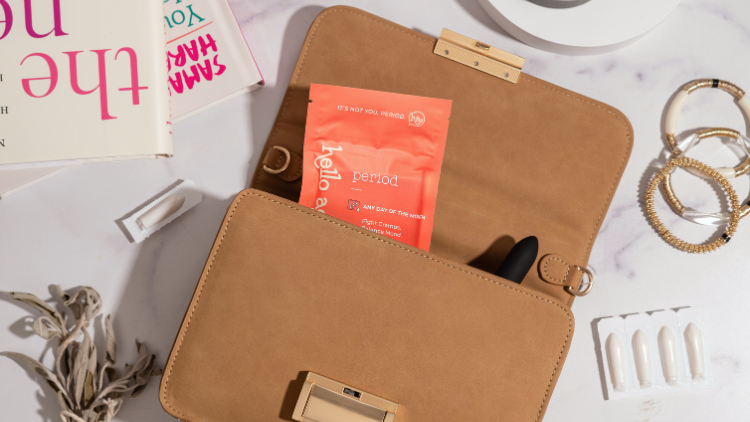 From an overhead view, a Hello Again Period product peeks out of a Citizen Hyde handbag.