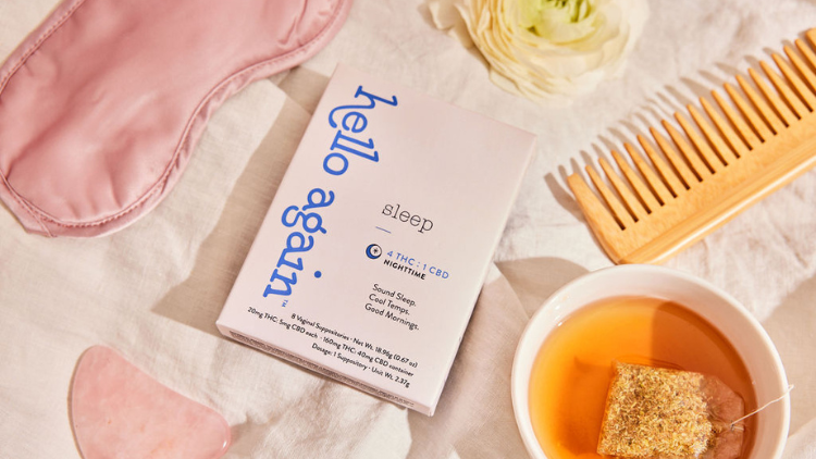 Overhead photo of Hello Again Sleep sitting on a linen backdrop surrounded by a comb, herbal tea, and sleep mask.