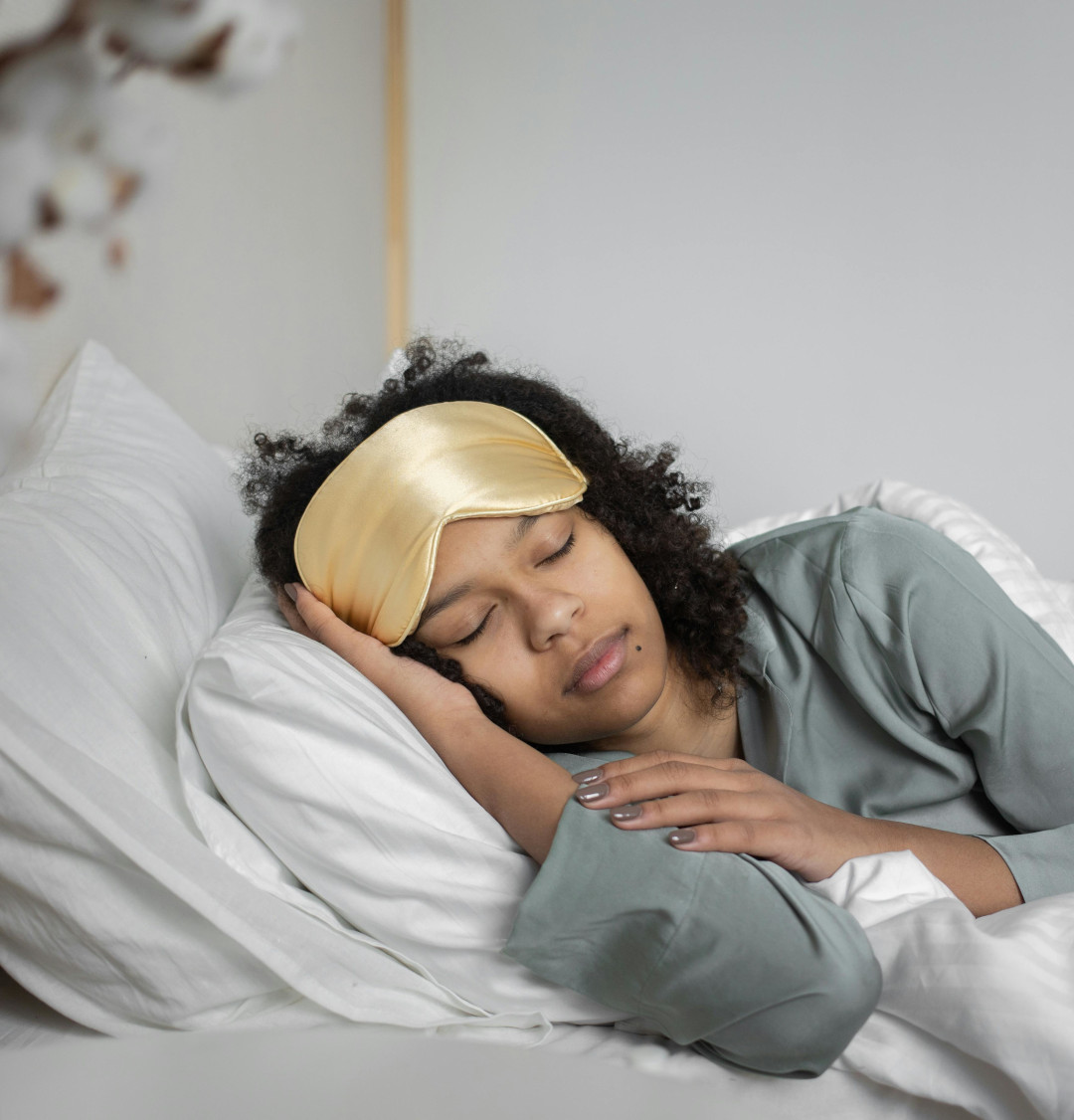 Woman sleeping with a face mask on her forehead