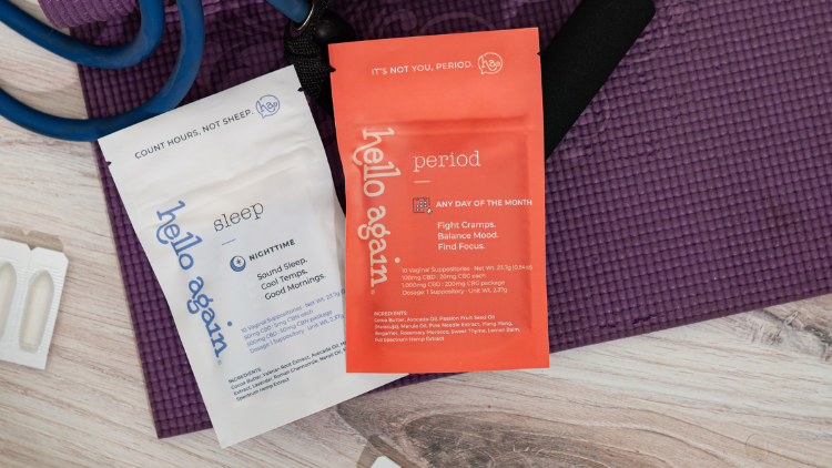 Hello Again Sleep and Period products sit on top of a purple exercise mat.