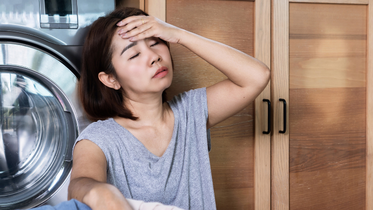Woman experiencing a hot flash and fatigue at home, illustrating why many seek CBD for menopause symptoms such as headaches and temperature swings.