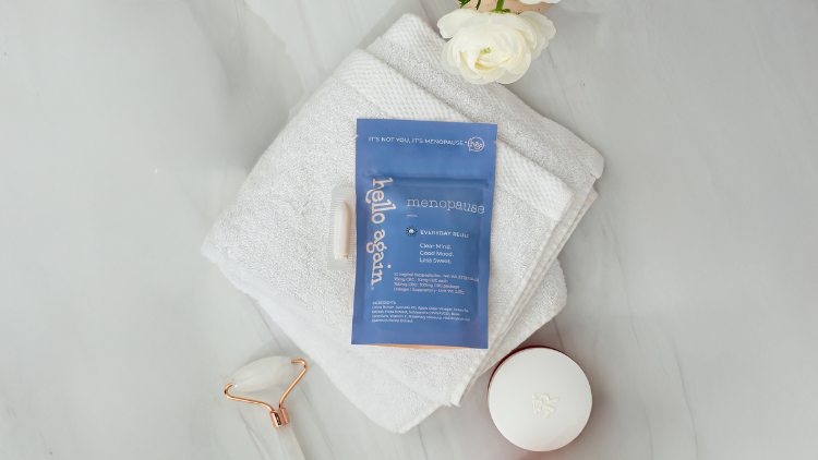 Hello Again Menopause product on folded towel with self-care items, supporting relief from signs of menopause
