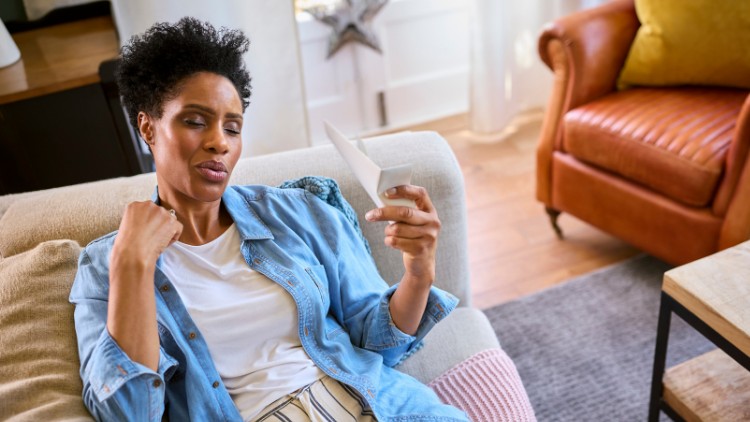 Woman experiencing physical discomfort at home, representing common signs of menopause like hot flashes and body tension