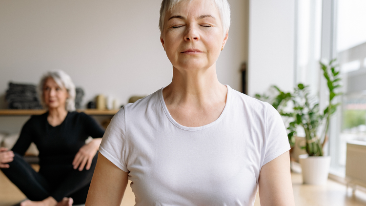 Woman practicing mindfulness while learning about hormone biomarkers and wellness.