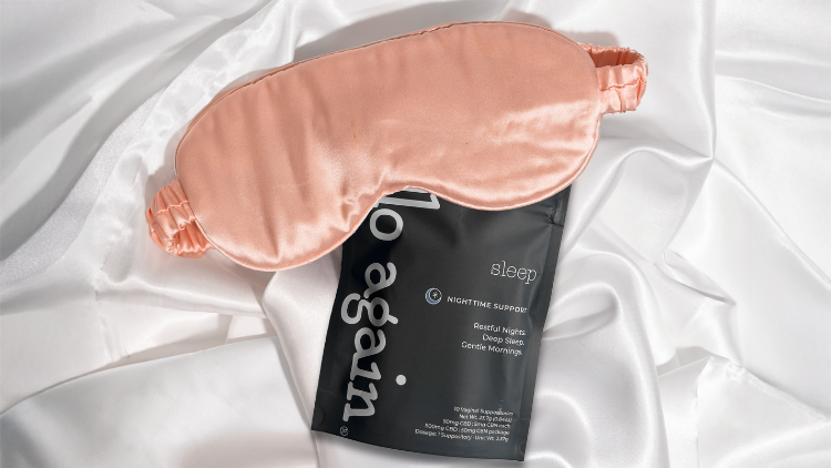 Hello Again Sleep CBN suppositories displayed with a satin sleep mask, highlighting a nighttime wellness routine featuring CBN for sleep.
