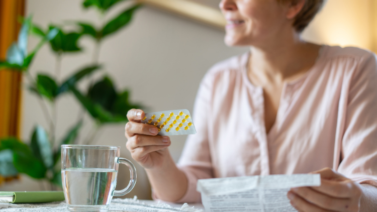 Woman reviewing medication at home while exploring HRT alternatives for menopause support.