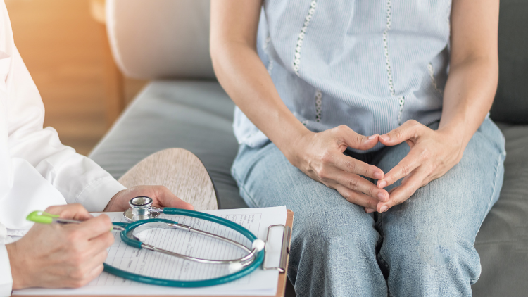 Woman discussing menopause and women's health with a healthcare provider during a medical consultation.
